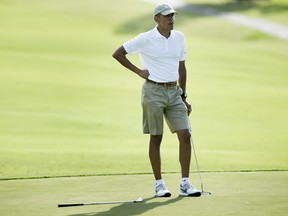 Barack Obama waits to hit on the 18th green at the Mid-Pacific Country Club golf course December 28, 2015 in Kailua, Hawaii