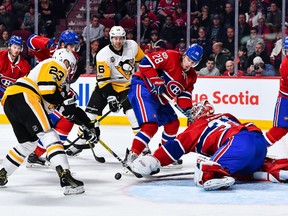 Goaltender Carey Price of the Montreal Canadiens reaches for the puck while Scott Wilson, left, of the Pittsburgh Penguins tries to get a shot at the Bell Centre on Wednesday in Montreal.