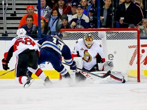 Mike Condon of the Ottawa Senators stops a shot from Cam Atkinson of the Columbus Blue Jackets as Mike Hoffman of the Ottawa Senators skates back on defense during the third period on Thursday at Nationwide Arena in Columbus, Ohio. Ottawa defeated Columbus 2-0.