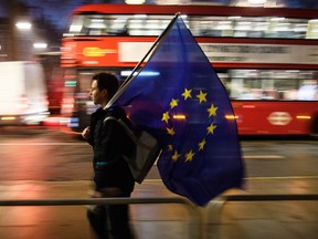 A man carries a European Union flag outside the Supreme Court in Parliament Square