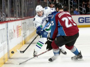 Troy Stecher of the Vancouver Canucks advances the puck against Mikhail Grigorenko of the Colorado Avalanche at the Pepsi Center in Denver on Wednesday night.