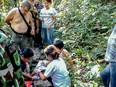 In this handout photo by Thai authorities of the Khao Yai National Park and taken on January 1, 2017, French national Muriel Benetulier is tended to by Thai medics and Park Rangers in Thailand after she was bitten by a crocodile.