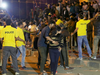 In this photograph taken on January 1, 2017, an Indian man helps a woman (C) leave as police personnel try to manage crowds during New Year's Eve celebrations in Bangalore on January 1, 2017.