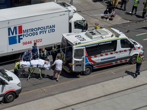 Paramedics help injured people after a car drove into pedestrians in the centre of Melbourne on January 20, 2017