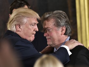 US President Donald Trump (L) congratulates Senior Counselor to the President Stephen Bannon during the swearing-in of senior staff in the East Room of the White House on January 22, 2017 in Washington, DC.