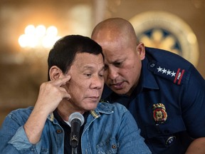 Philippine President Rodrigo Duterte (left) talks to Philippine National Police (PNP) Director General Ronald Dela Rosa during a press conference at the Malacanang palace in Manila on January 30, 2017.