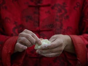 A man pinches a dumpling into shape during a community gathering ahead of Lunar Chinese New Year in a village on the outskirts of Beijing, China, Jan. 26, 2017.