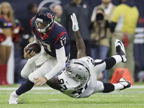 Texans quarterback Brock Osweiler scrambles for a first down against Oakland Raiders defensive end Mario Edwards during the first half of their AFC wild card playoff game Saturday in Houston.