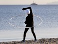 An man exercises with a huge ring at he beach of the Baltic Sea on Timmendorfer Strand, Germany, Friday, Dec. 30, 2016