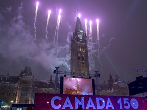Fireworks light up the sky behind the Peace Tower during a New Year's Eve celebration on Parliament Hill, Saturday, Dec. 31, 2016 in Ottawa.