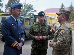 Canadian and Ukrainian servicemen talk during the opening ceremony of a joint military exercises in Lviv, Ukraine, Sept. 14, 2015. Ukraine's envoy says his country is growing concerned about whether Canada will to provide military support.