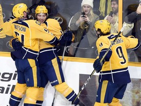 Calle Jarnkrok, second from left, celebrates with Predators teammates Austin Watson, left, and Filip Forsberg after scoring the winning goal in overtime against the Vancouver Canucks on Tuesday night in Nashville.