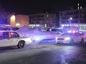 Police survey the scene of a shooting at a Quebec City mosque on Sunday, Jan. 29, 2017.