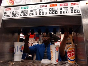 Employees fill cups with Coca-Cola from a fountain dispenser at a New York City Burger King restaurant on Tuesday, June 17, 2003.