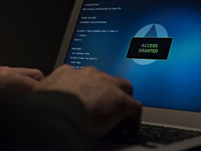 A man types on a laptop computer