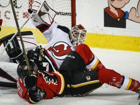 Matthew Tkachuk of the Calgary Flames collides with New Jersey Devils' goaltender Keith Kinkaid during NHL action Friday night in Calgary. The Devils were 2-1 winners.