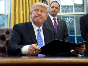 U.S. President Donald Trump signs an executive order withdrawing the U.S. from the Trans-Pacific Partnership trade deal.