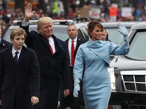 President Donald Trump waves to supporters as he walks the parade route with first lady Melania Trump and their son Barron during the Inaugural Parade on Jan. 20, 2017 in Washington, D.C.