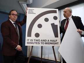 From left, Lawrence Krauss, theoretical physicist, chair of the Bulletin of the Atomic Scientists†Board of Sponsors; Thomas Pickering, co-chair of the International Crisis Group; and David Titley, a nationally known expert in the field of climate, the Arctic, and national security, unveil the Doomsday Clock during a news conference at the National Press Club in Washington, Thursday, Jan. 26, 2017, announcing that the Bulletin of the Atomic Scientist have moved the minute hand of the Doomsday Clock to two and a half minutes to midnight.