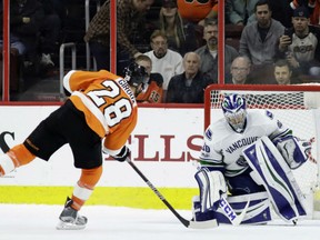 Philadelphia Flyers' captain Claude Giroux scores past Vancouver Canucks goaltender Ryan Miller in the shootout for the margin of victory in NHL action Thursday night in Philadelphia. The Flyers were 5-4 winners.