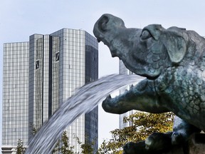 FILE - In this Oct. 11, 2016 file photo water spills out of a small dragon sculpture on a fountain with the headquarters of the Deutsche Bank in background in Frankfurt, Germany. The management board said in a message to employees Wednesday, Jan. 18, 2017 that vice presidents, directors and managing directors will receive group variable compensation but no individual bonuses for the financial year. (AP Photo/Michael Probst, file) ORG XMIT: LGL101