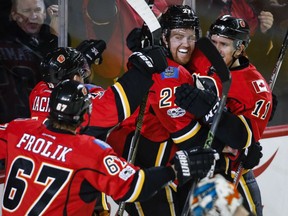 Dougie Hamilton, centre right, celebrates his game-winning goal with Flames teammates late in the third period against the San Jose Sharks in Calgary on Wednesday night.