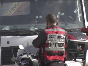 This frame grab from video, shows an Israeli emergency services personnel at scene of a truck-ramming attack in Jerusalem that killed at least four people and wounded several others in Jerusalem, Sunday, Jan. 8.