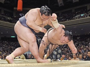 Ozeki Kisenosato, left, pushes Mongolian grand champion Hakuho out of the ring during the final day bout of the New Year Grand Sumo Tournament at Ryogoku Kokugikan sumo hall in Tokyo Sunday, Jan. 22, 2017. Kisenosato, who had secured his first championship victory on Saturday, finished the 15-day tournament with 14-1 win-loss records.