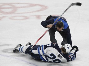 Winnipeg Jets forward Patrik Laine is helped by a trainer after being hit during the third period of their game against the Sabres in Buffalo on Saturday night.