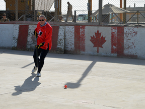 Canada's ambassador to Afghanistan, Ken Neufeld, stickhandles during the final hockey game at Kandahar Airfield before the rink was dismantled on Dec. 27, 2016.