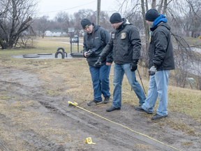 Jeff Schrier/The Saginaw News via AP measure tire tracks on Tuesday, Jan 24, 2017, near the scene of the shooting of Demarlon Thomas, 31, in Saginaw .