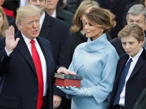 Donald Trump takes the oath of office as his wife Melania Trump holds the bible and his son Barron Trump looks on in Washington, D.C. on January 20, 2017