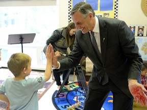 Saskatchewan Education Minister Don Morgan gets a high five from five-year-old Boston Hickey at the Awasis Child Care Co-op at the U of Regina on June 17, 2014.