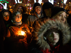 People gather in remembrance of the victims of Sunday's shooting at a Quebec City mosque in Edmonton Alta, on Monday Jan. 30, 2017.