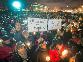 People attend a vigil for victims of the mosque shooting in Quebec City Monday, Jan. 30, 2017 in Montreal.