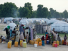 In this Tuesday, Aug. 30, 2016, file photo, people displaced by Islamist extremists fetch water at the Muna camp in Maiduguri, Nigeria.