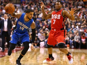 D.J. Augustin, left, of the Orlando Magic, tries to work the ball around defender Kyle Lowry of the Toronto Raptors during NBA action Sunday night at the Air Canada Centre in Toronto. Augustin had 21 points coming off the bench helping the Magic post a 114-113 victory. Lowry had 33 points in a losing cause.