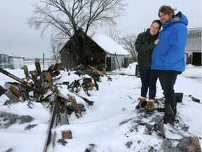 Emilie Deschenes and her husband Ken Tremblay stand on their burnt down family house near Alfred Ontario  Monday Jan 3, 2017.  It took firefighters on hour to get there because  the wrong fire department was dispatched.