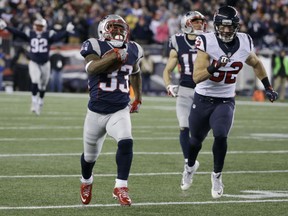 New England Patriots running back Dion Lewis runs ahead of the Houston Texans' Brian Peters for a touchdown during the first half of their AFC divisional playoff game on Saturday night in Foxborough, Mass.