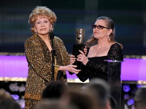 In this Jan. 25, 2015, file photo, Carrie Fisher, right, presents her mother Debbie Reynolds with the Screen Actors Guild life achievement award at the 21st annual Screen Actors Guild Awards at the Shrine Auditorium in Los Angeles.