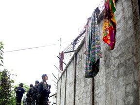Armed police patrol the perimeter fence of the district jail after more than 100 inmates escaped in the town of Kidapawan on the southern island of Mindanao on January 4, 2017.