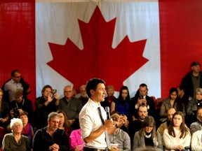 Prime Minister Justin Trudeau speaks in front of a Canadian flag during his town hall meeting with about 265 people in Memorial Hall in Kingston's City Hall on Thursday January 12 2017.