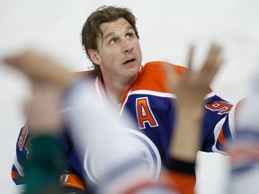 In this April 12, 2014 file photo, Ryan Smyth tosses pucks into the crowd before his final game with the Edmonton Oilers.