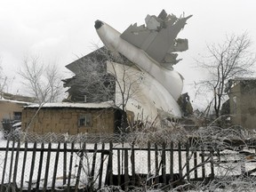 The tail of a crashed Turkish Boeing 747 cargo plane lies at a residential area outside Bishkek, Kyrgyzstan Monday, Jan. 16, 2017