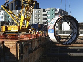 In this Oct. 19, 2016, file photo, workers lower the tail shield section of a tunnel boring machine into a 45 foot deep pit, during a ceremonial naming and lowering for the Regional Connector Transit Project downtown Los Angeles. Just weeks after suddenly tweeting "Traffic is driving me nuts" and "am going to build a tunnel boring machine and just start digging," Elon Musk, the SpaceX and Tesla founder says it's on the verge of happening.