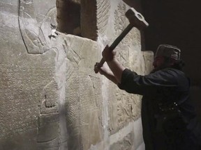 This image made from video posted online by ISIL militants in April 2015 shows a militant taking a sledgehammer to a stone carving at the ancient site of Nimrud near Mosul, Iraq
