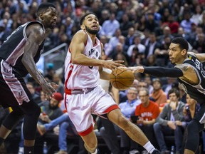 Cory Joseph of the Raptors drives between San Antonio Spurs' Dewayne Dedmon (left) and Danny Green during the second half of their game at the Air Canada Centre in Toronto on Tuesday night.