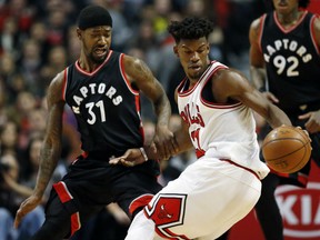 Jimmy Butler, right, of the Bulls controls the ball against Toronto Raptors' Terrence Ross during the first half of their game on Saturday night in Chicago.