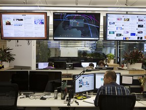 An employee sits at a desk beneath television screens at the headquarters of Kaspersky Lab, a cyber-security firm, in Moscow, Russia, on Tuesday, Dec. 9, 2014.