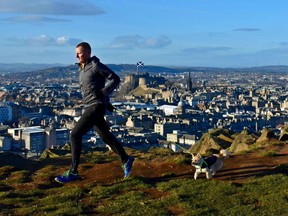 Dion Leonard and Gobi the dog run through the hills of Edinburgh.